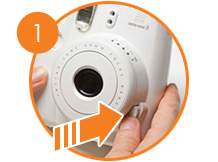 Pulsa el botón ubicado al lado derecho del lente para encender la cámara Instax mini 8.